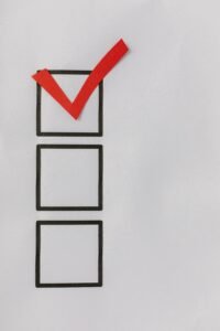 Checklist met drie vakjes waarvan het bovenste is afgevinkt met een rood vinkje.